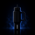 A black insulated tumbler with a handle, lid, and straw, shown on a dark reflective surface with blue glow effects. The tumbler has a visible COOLEST logo near the lower front.