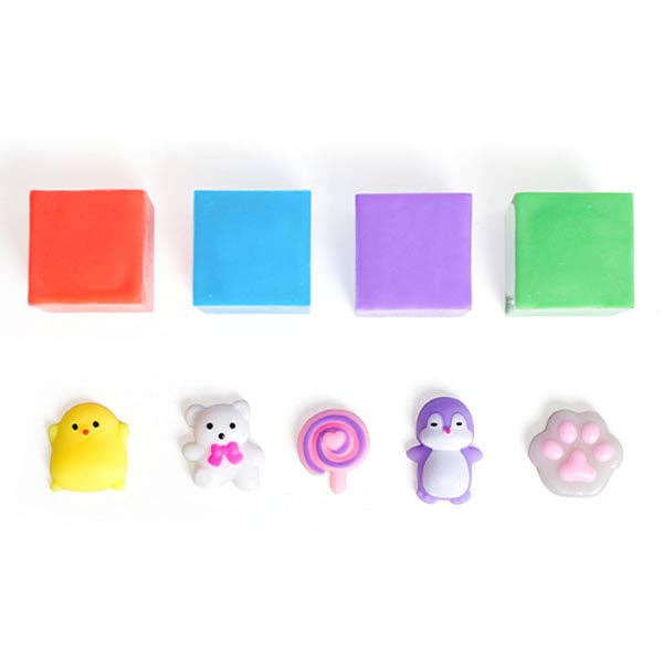 A set of colorful, squishy mini toys and small blocks on a white background, including a red block, a blue block, a purple block, a green block, a yellow chick, a white bear with a pink bow, a pink swirl lollipop, a purple penguin, and a pink paw print.